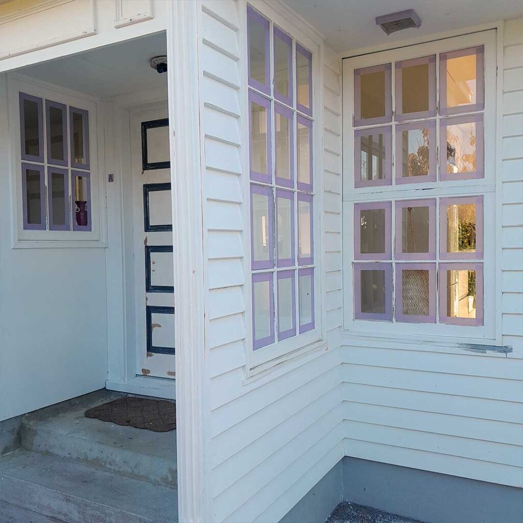 This images features white weatherboards, white windows and white door sanded and prepared for house painting.