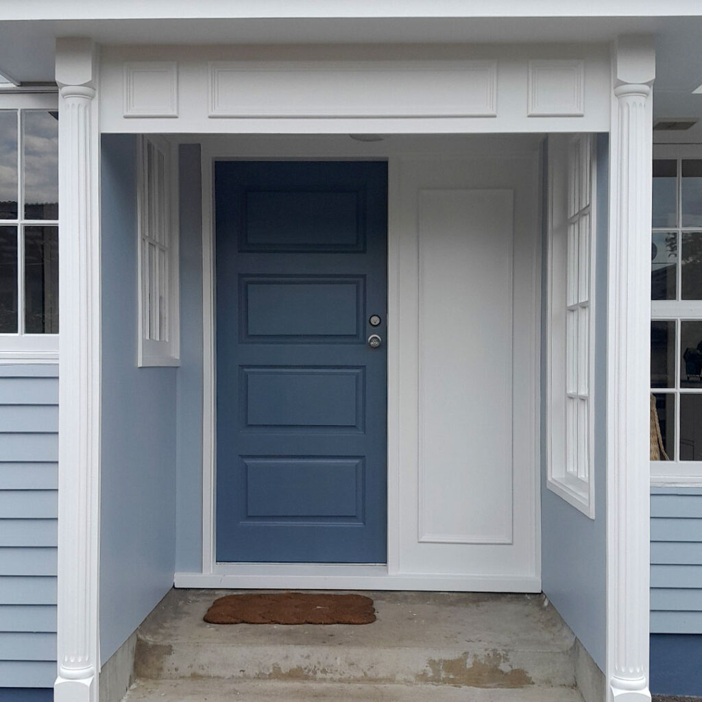 The image is of a white house with grey doors. The house has been painted recently.