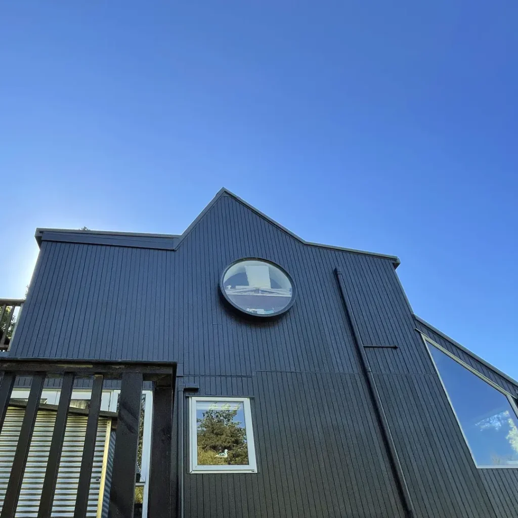 The image shows a building with a round window. The building appears to have been painted with Weathershield® ColourGuard™ Rawene, featuring a blue sky in the background.