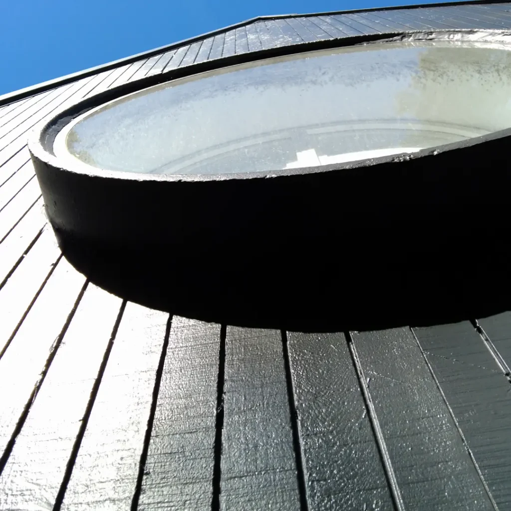 The photo shows a newly painted round window. The setting appears to be outdoors under the sky. It was taken after an exterior painting project using Weathershield® ColourGuard™ Rawene.