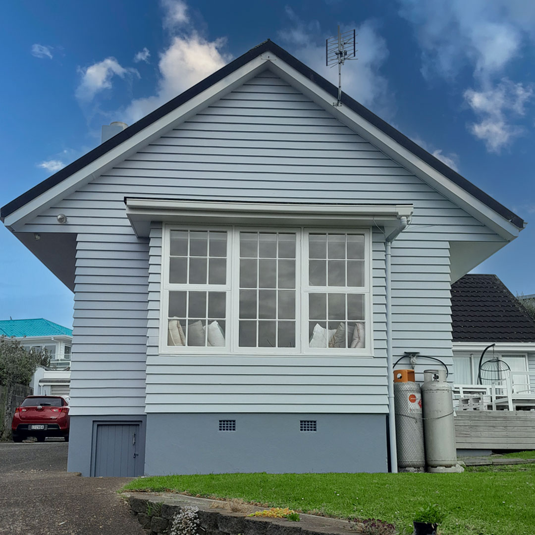 a house with a blue roof and a blue sky with clouds