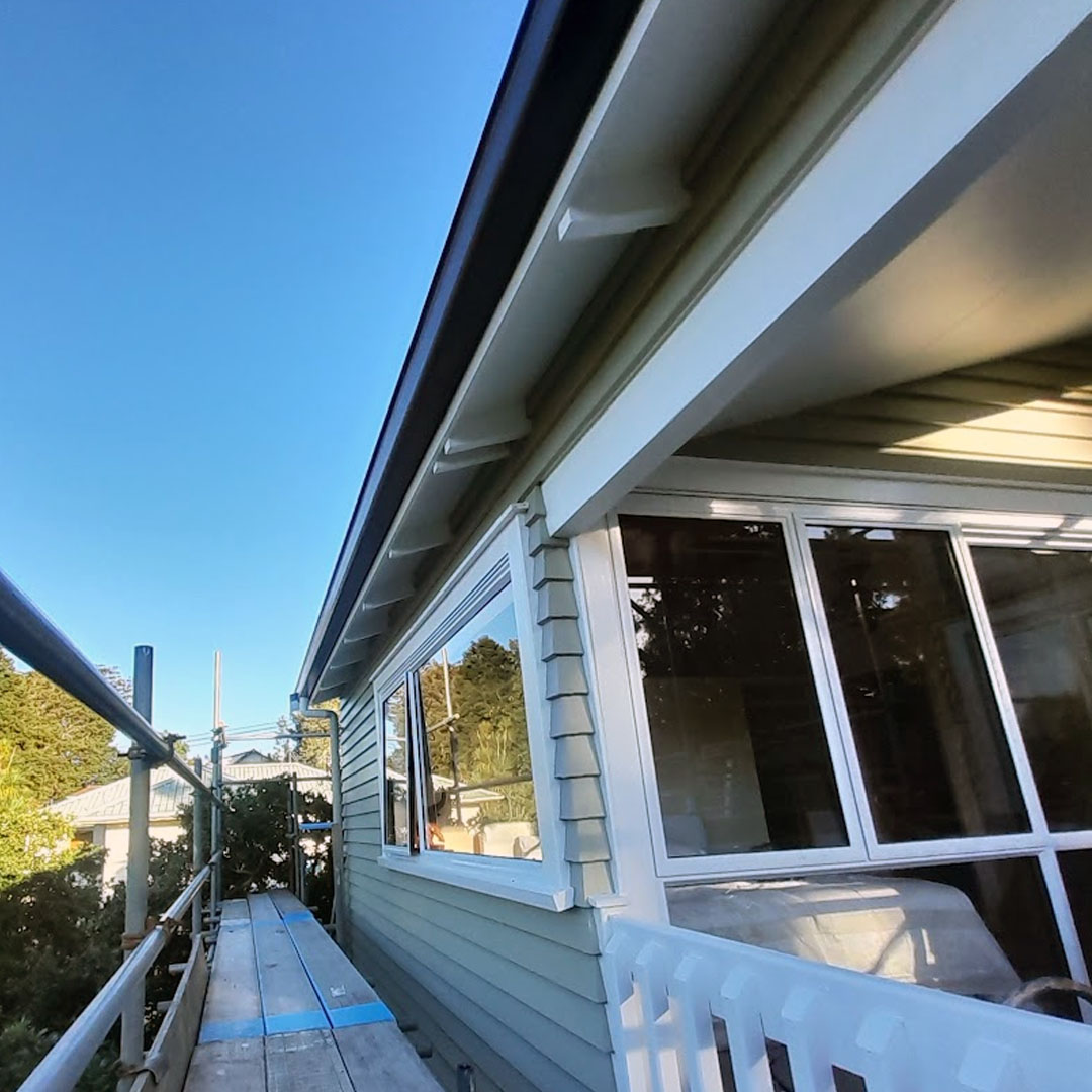 A green house with white trim and handrails