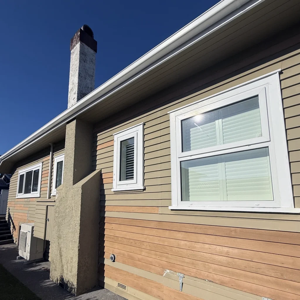 Weathered villa exterior with faded paint and peeling timber before repainting in Bayswater, Auckland.